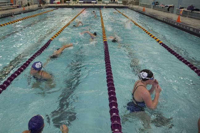 Members of the WVHS girls varsity swim team warm up before a meet in the district&#x2019;s newly renovated swimming pool.