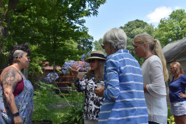 Nicole Hixon chats with visitors to her garden in Warwick, N.Y and offers them strawberry hibiscus iced tea.