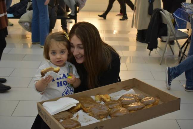 Rivkie Borenstein of the Orange County Chabad and her daughter pass out donuts.