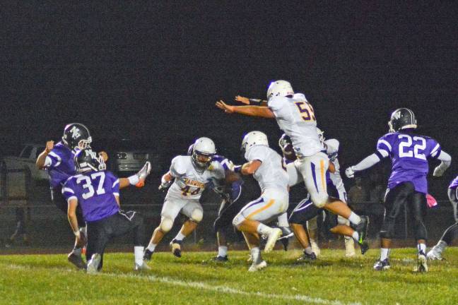 Provided photo Warwick-Valley defensive end Dan McNally blocks Monroe-Woodbury point after attempt. The Wildcats defeated the Crusaders 14-13 at Central Valley last Friday evening.