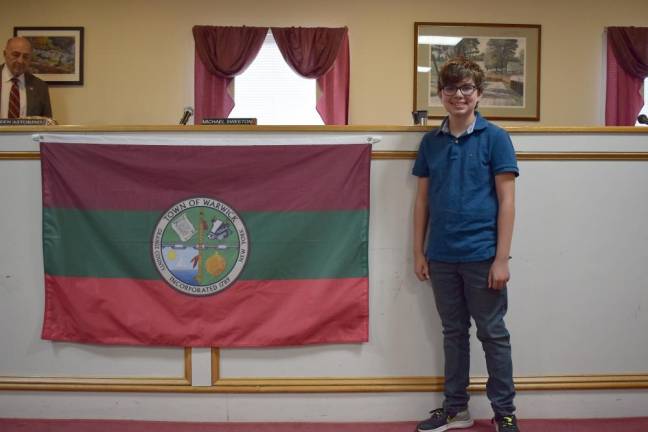 Aidan Harvey stood with the flag he designed for the Town of Warwick, adopted on May 24.