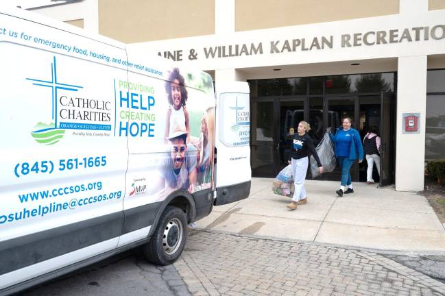 Mount Saint Mary College students help load bags of donated toys into a Catholic Charities van.