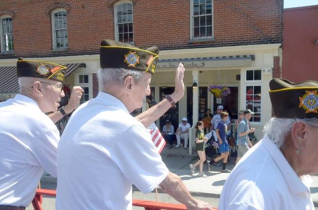 VFW men waving from float to street crowds.