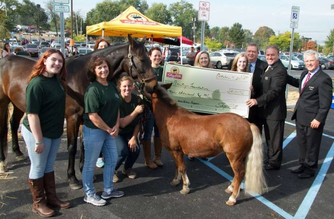Photo provided by ShopRite Representatives from ShopRite Supermarkets, Inc. present a check for $4,000 to The Amity Foundation for Healing with Horses during ShopRite of Warwick&#x2019;s grand reopening on Saturday, Oct. 7, as part of ShopRite&#x2019;s commitment to giving back to the communities its stores serve. From left to right: Hannah Horowitz, The Amity Foundation, Janet Buxbaum, The Amity Foundation, Christine Dykshoorn (kneeling), co-founder, The Amity Foundation, Corey DeMala-Moran, co-founder, The Amity Foundation, Genevieve Bonadonna (hidden), The Amity Foundation, Lori Dugan, human resources specialist, ShopRite Supermarkets, Inc., Katie Jonkoski, shopper advocate, ShopRite, Charlie Sladek, store director, Rich Martin, district manager, and Brett Wing, president, ShopRite Supermarkets, Inc. Also pictured are Beau the horse and Winston the pony, who help those who suffer from the psychological, emotional and relational effects of trauma.