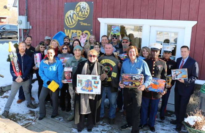 Photos by Roger Gavan On Dec. 11, contributors to the second annual Toys for Military Tots toy drive assembled at the office of radio WTBQ (1110 AM/93.5 FM) to celebrate the success of the program and the distribution of the toys. Front row from left, Bill Dawson of Dawson Motors, Hayley Coriaty from Legoland, Taylor Sterling (center), Bob Caridi, president of the Nam Knight along with Pat Rooney and other members of the Nam Knights, Frank Truatt and Orange County Executive Steve Neuhaus. Recipients in the rear rows include Pete and Laura Rollins representatives of the Disabled Vets of America and Kelly Williamson, program manager of the Airman and Family Readiness Program, Master Sgt.Sara Pastorello, head of Communication at Stewart Air Force Base along with service men and women from Stewart, and from the Child Care Council, Beth Mindes and Linda Martini along with Amanda Dana, Orange County Partnership and Susan Dean, director of Operations at McKesson.