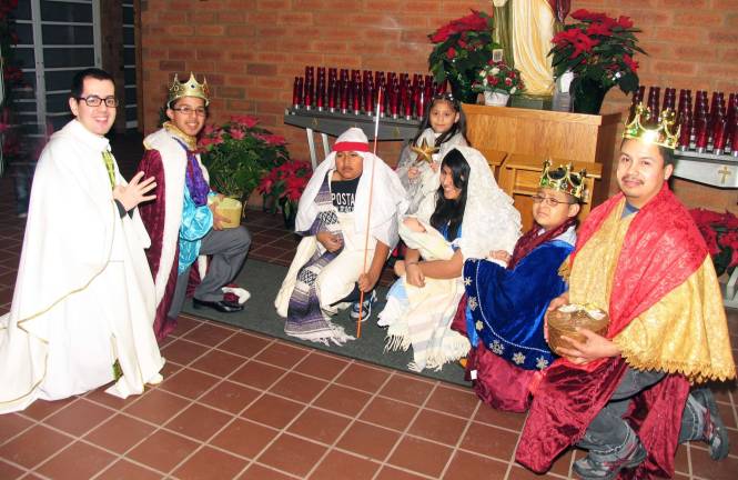 Photo by Roger Gavan After the Mass of the Epiphany, the Rev. Adaly Rosado posed for a photograph with the children in costumes who were dressed as Mary, carrying the baby Jesus, Joseph and the Three Wise Men.