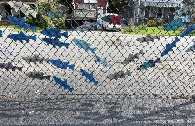 “Something Fishy” was an early community art project (pre-COVID) by Village Trustee Nancy Clifford. She got 164 fishes decorated by GWL residents and then installed them on the fence outside the community center. Photo by Peter Lyons Hall.