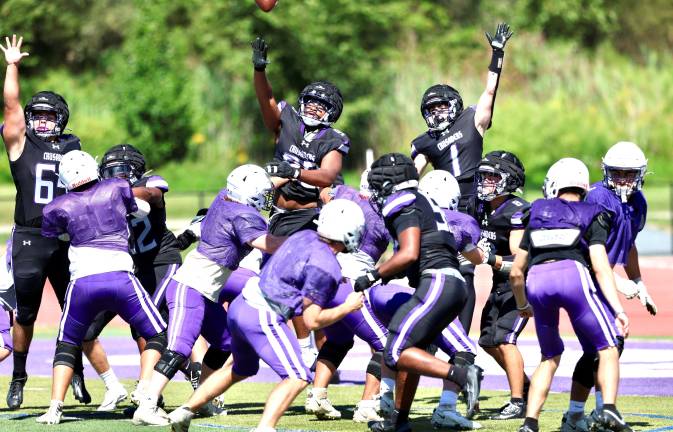 Crusader defenders leap high in their attempt to block a Wildcat extra point.