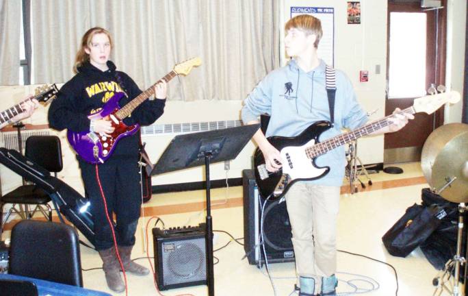 Rocking out during Guitar Club rehearsal are seventh-grader Colleen O'Brien (on left) on guitar and eighth-grader Harrison Dempster on bass.