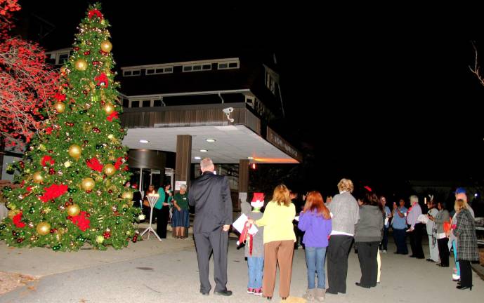 Attendees listen to an invocation and blessing of the tree by Director of Pastoral Care Suzanne Evanoff.