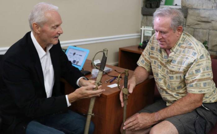 Photo by Roger Gavan Appraiser and auctioneer William J. Jenack discusses his estimated value of antiques with David Fitzgerald.