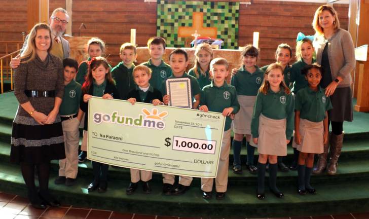 Ira's Grade 2 class will exchange letters with the poor children of Davao. From left, St. Stephen - St. Edward School Principal Bethany Negersmith, Mayor Michael Newhard, Grade 2 students with Ira Faraoni (center) and their teacher Marianne Sims (far right.)