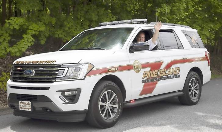 The fire chief waves during the Memorial Day drive by parade in Pine Island on Monday, May 25. Photo by Robert G. Breese.