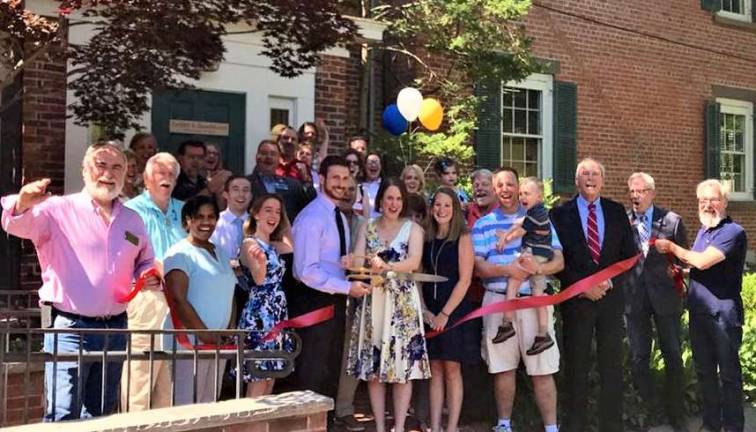 Provided photo On June 21, local officials and members of the Warwick Valley Chamber of Commerce joined Jacob Tuckfelt and Valerie K. Zammitt, center, and their relatives, friends and colleagues to celebrate the one-year anniversary of the merger of their firms with a ribbon-cutting ceremony.