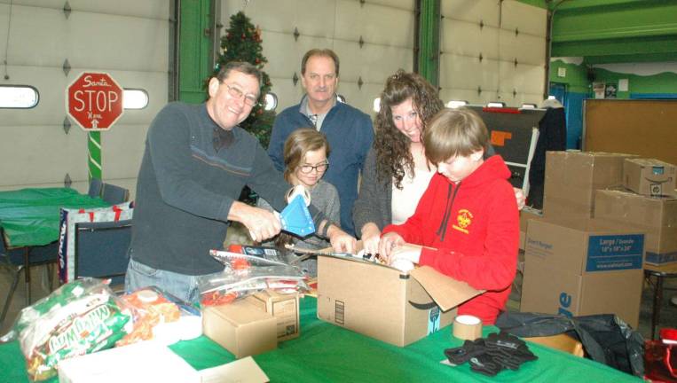 Photo by Ed Bailey In Greenwood Lake, pictured from left to right, are Dan Pitiger, Kira Sarine, Bill Sahler and Katheleen Buckley Holder, who are packing holiday care packages for Billy Sahler and other members of his 7th Special Forces group in Afghanistan.