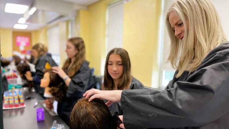 Warwick Valley High School students learn cosmetology by working with teacher Kathleen Bettello.