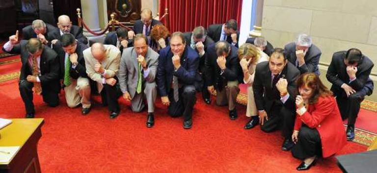 Assembly members take a moment - and a knee - for a Tebow Prayer