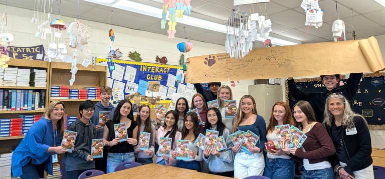 Interact Club members with copies of “Emily and the Mango Man,” a book shared with Honduran children as part of a literacy initiative.