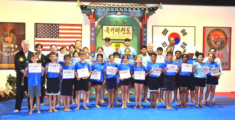Warwick Junior Police Academy participants, along with Warwick Police officers and Chosun instructors, at the Chosun Taekwondo Academy.