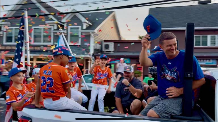 Florida’s Colin Riordan, Austin Caldwell, Rylen Mejia, Sebastian Clark, Joe Riordan, coach Matt McKeon and Manager Ray Younghans are toasts of the town as they ride down a confetti-filled Main Street Monday, July 20 after winning the NYS Section 3 championship.