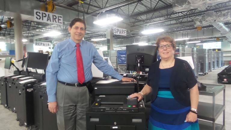 Republican Commissioner David Green and Democratic Commissioner Susan Bahren with Orange County's voting machines earlier this year (Photo by Frances Ruth Harris)