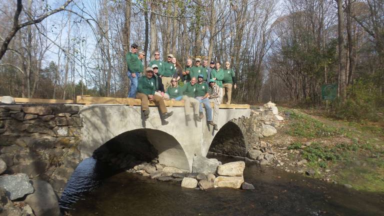 The volunteer crew from the New York New Jersey Trail Conference enjoys the view from the newly rebuilt bridge over the Seely Brook (Photo by Frances Ruth Harris)