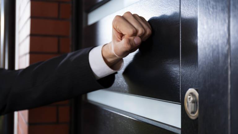 Close-up of hand knocking on the door