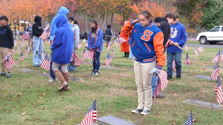 After placing each flag at the Veterans Cemetery, S.S. Seward JROTC cadets read aloud the name of each veteran and saluted.