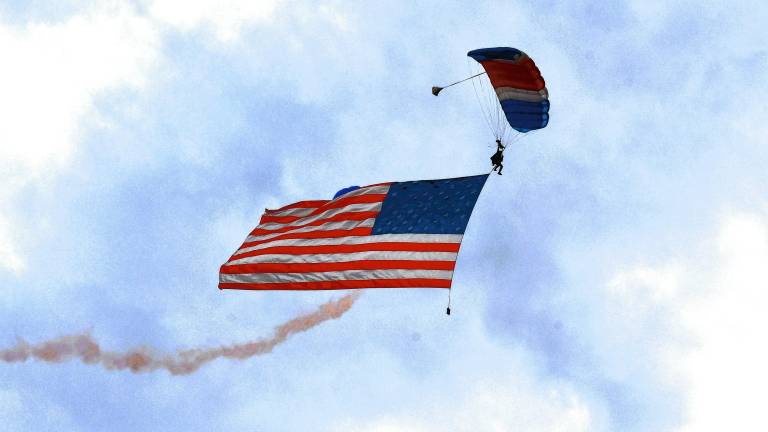A huge American flag is held by parachutists during the NJ Airshow on Friday evening, June 13 in West Milford. (Photo by Maria Kovic)