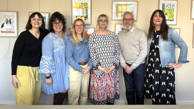 Lisa Cullen, center, newly selected Village of Warwick Artist-in-Residence, stands with (left to right) Aliza Schiff, Village of Warwick special projects coordinator; Nicole Hixon, former AIR; Melissa Shaw-Smith, Wickham Works executive director; Mayor Michael Newhard; and Village Trustee Mary Collura in front of an exhibit of Cullen’s work at the Albert Wisner Library. Library Director Lisa Laico also served on the jury to select the 2026-2027 AIR.