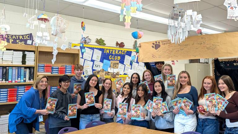 Interact Club members with copies of “Emily and the Mango Man,” a book shared with Honduran children as part of a literacy initiative.
